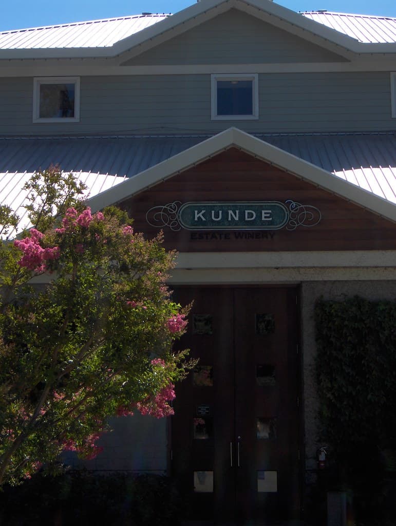 Gabled Kunde tasting room entrance with its name sign and a flowering crape myrtle