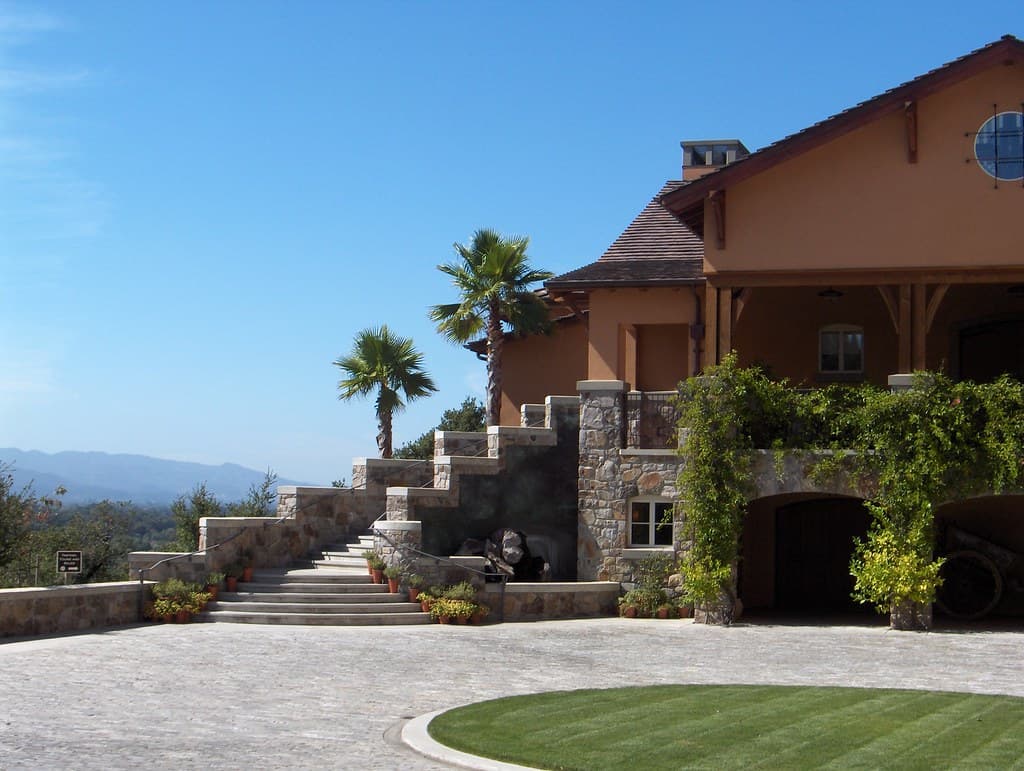 Stone stairway, palms and a round lawn at the hilltop Silverado Vineyards winery, with the valley and hills beyond