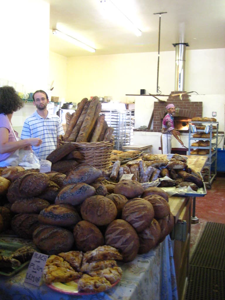 Rustic loaves and pastries piled on the counter inside Wild Flour Bread in Freestone