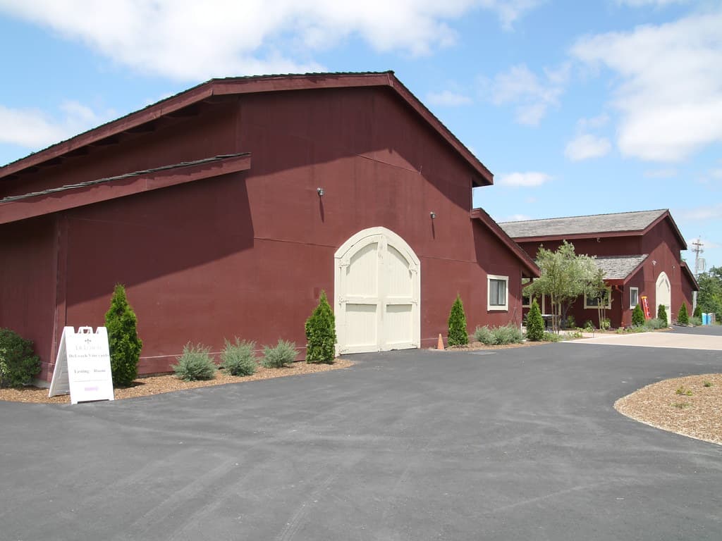 Red barn-style winery building with an arched door at DeLoach Vineyards