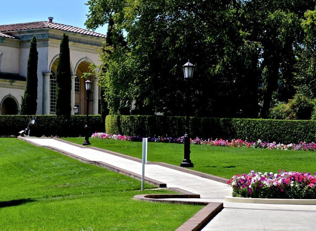 Lawn, lamp-lined path and flower beds in front of the Italianate villa at Ferrari-Carano