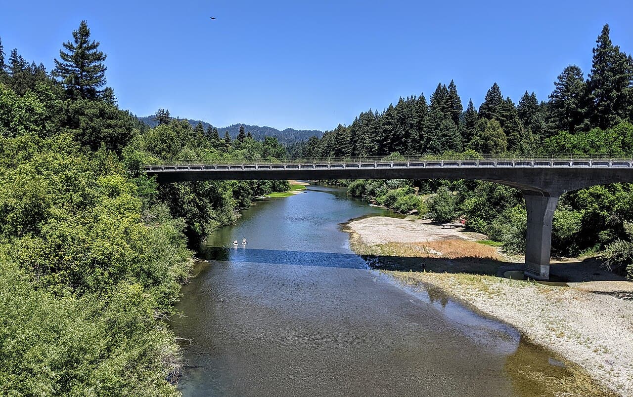 The Russian River and the Highway 116 bridge at Guerneville, with a gravel bank and redwood-covered hills