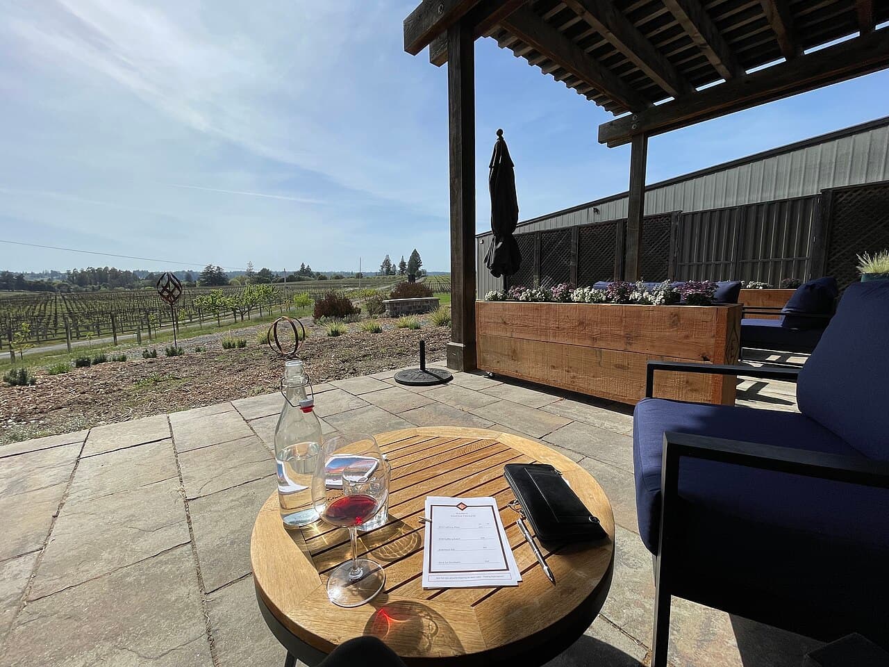 Patio table with a tasting flight on the covered terrace overlooking the vineyard at Emeritus
