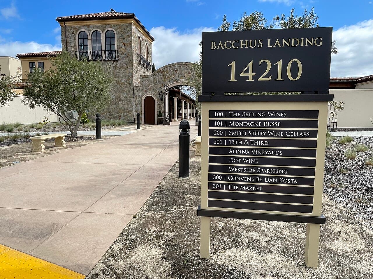 Bacchus Landing 14210 directory sign in front of the Tuscan-style stone buildings and walkway