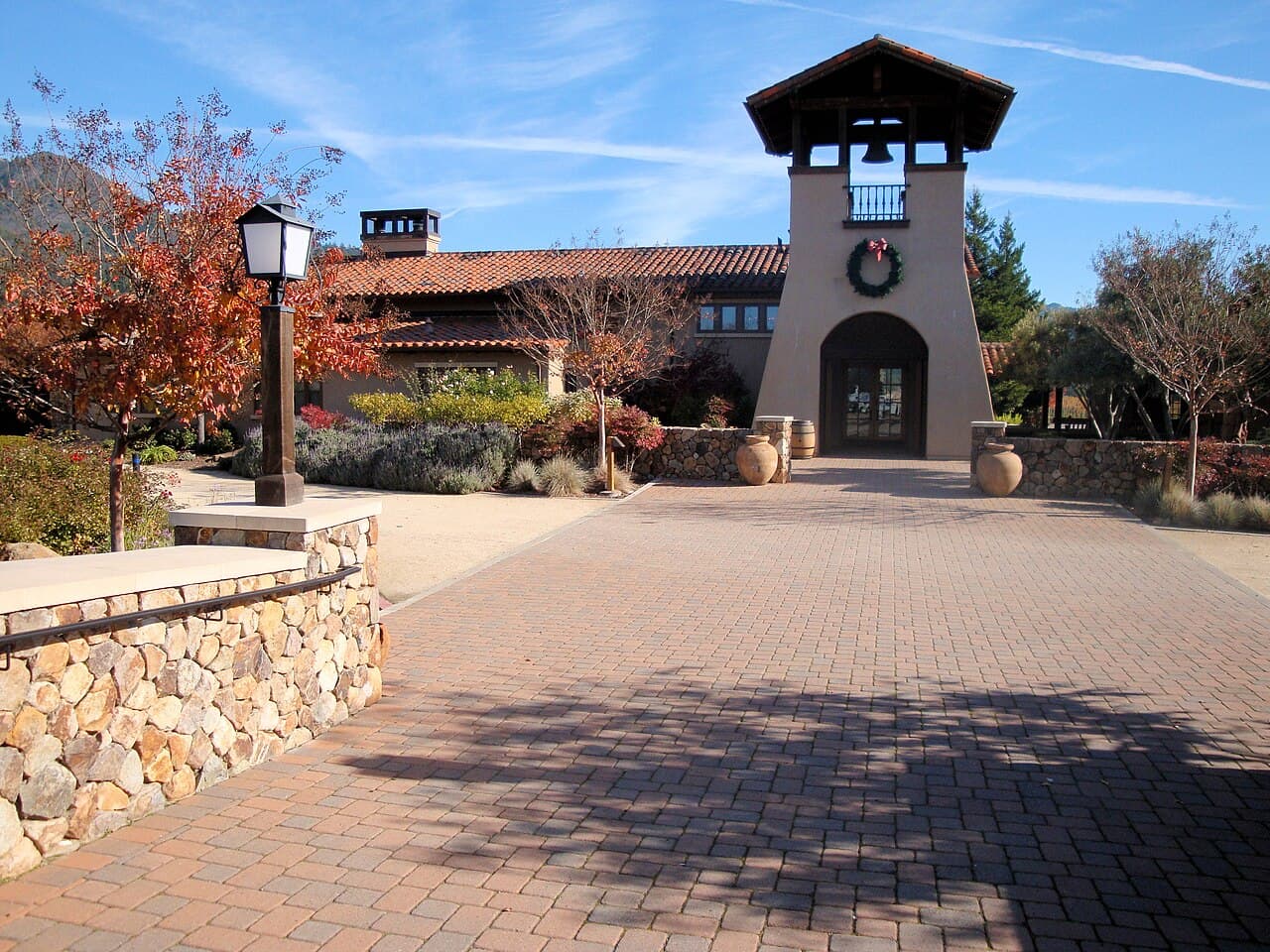Mission-style bell tower and brick entry plaza framed by autumn trees at St. Francis Winery