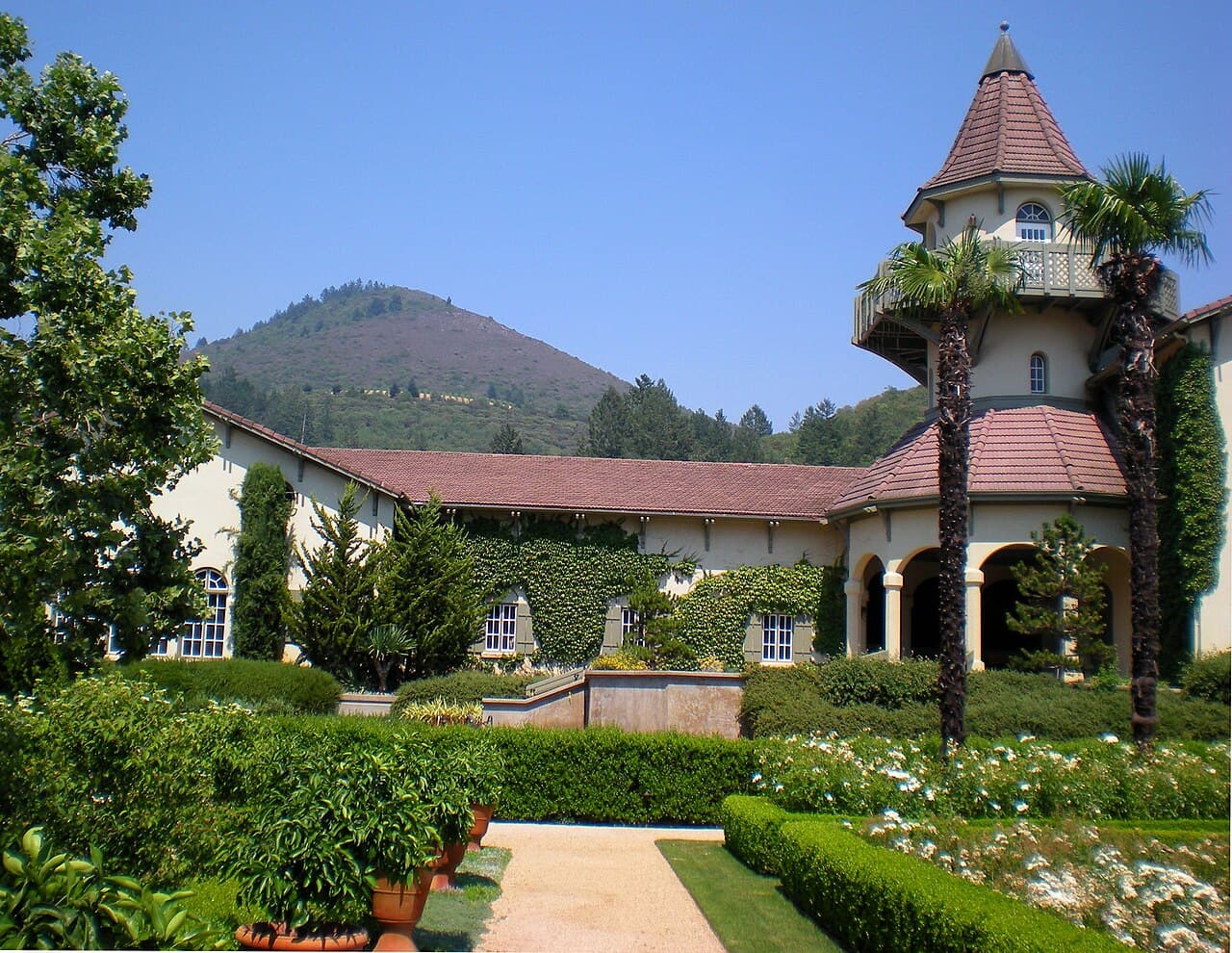 Formal gardens and lawn before the turreted Chateau St. Jean building below Sugarloaf Ridge