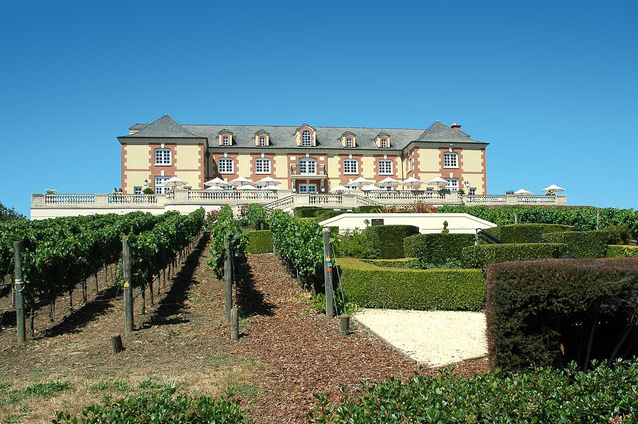 French chateau-style Domaine Carneros winery on its hilltop above vineyard rows and clipped hedges