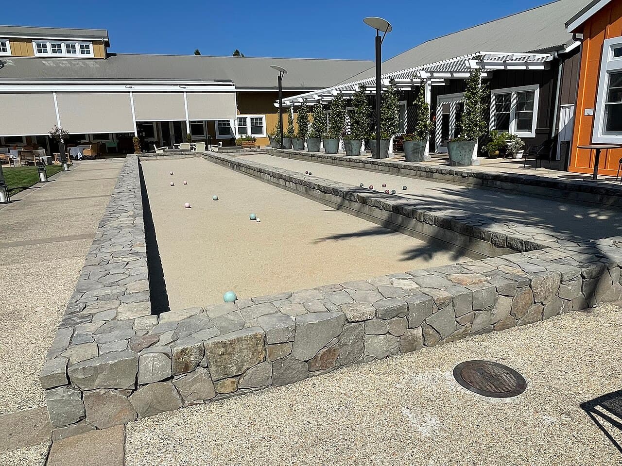 Stone-edged bocce court next to the shaded arcade at Carneros Resort