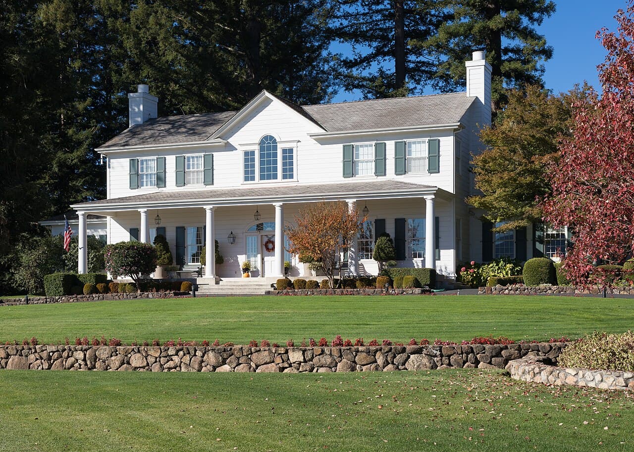 White colonial-style farmhouse above a broad lawn and stone walls at Robert Young Estate Winery