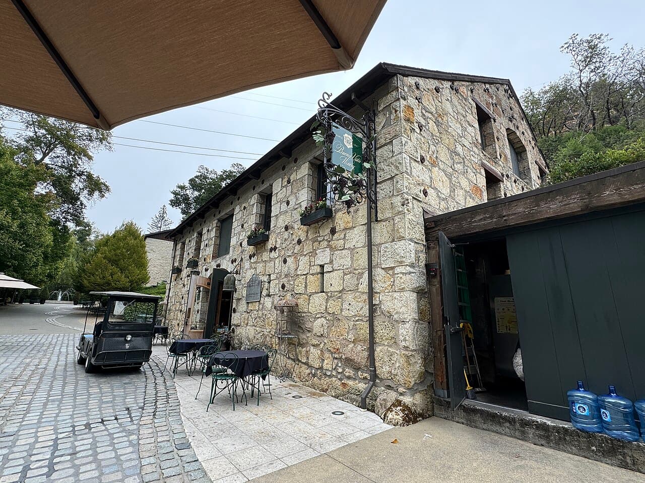 Café tables on the cobblestone courtyard beside the historic stone cellar at Buena Vista Winery