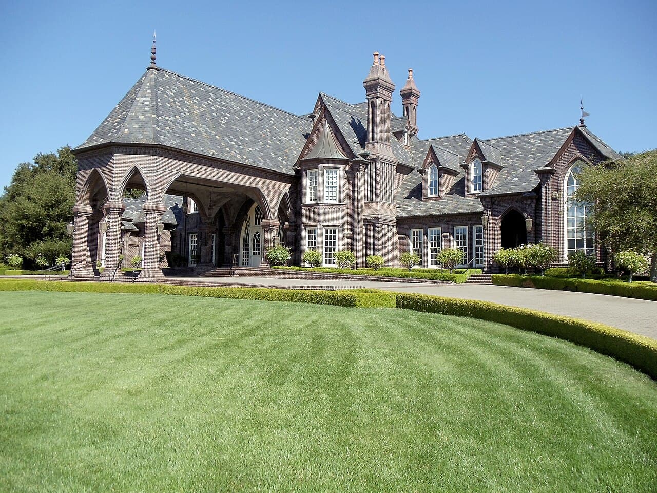 Gothic-style brick Ledson castle behind a broad manicured lawn in Kenwood
