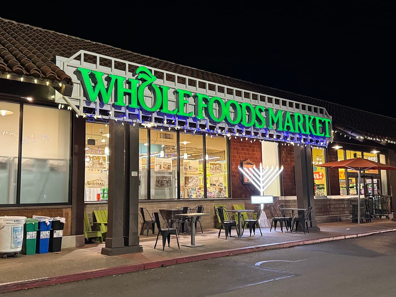 Whole Foods Market storefront in Sonoma at night, with café tables and chairs on the front patio